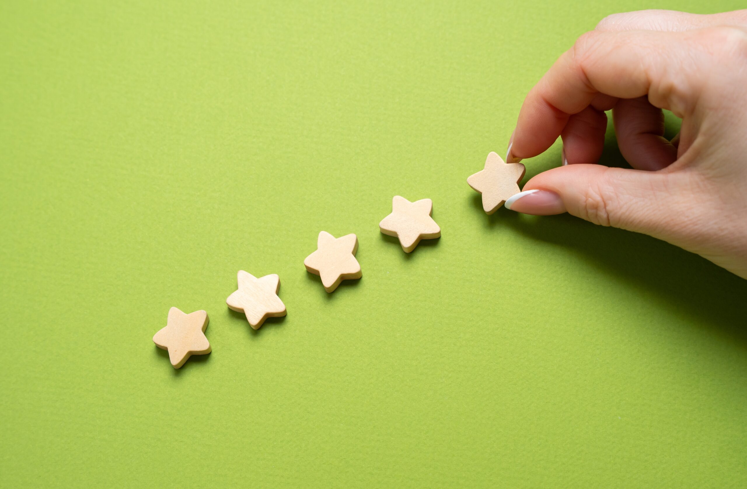 A customer's hand putting a fifth star as a sign of brand trust.