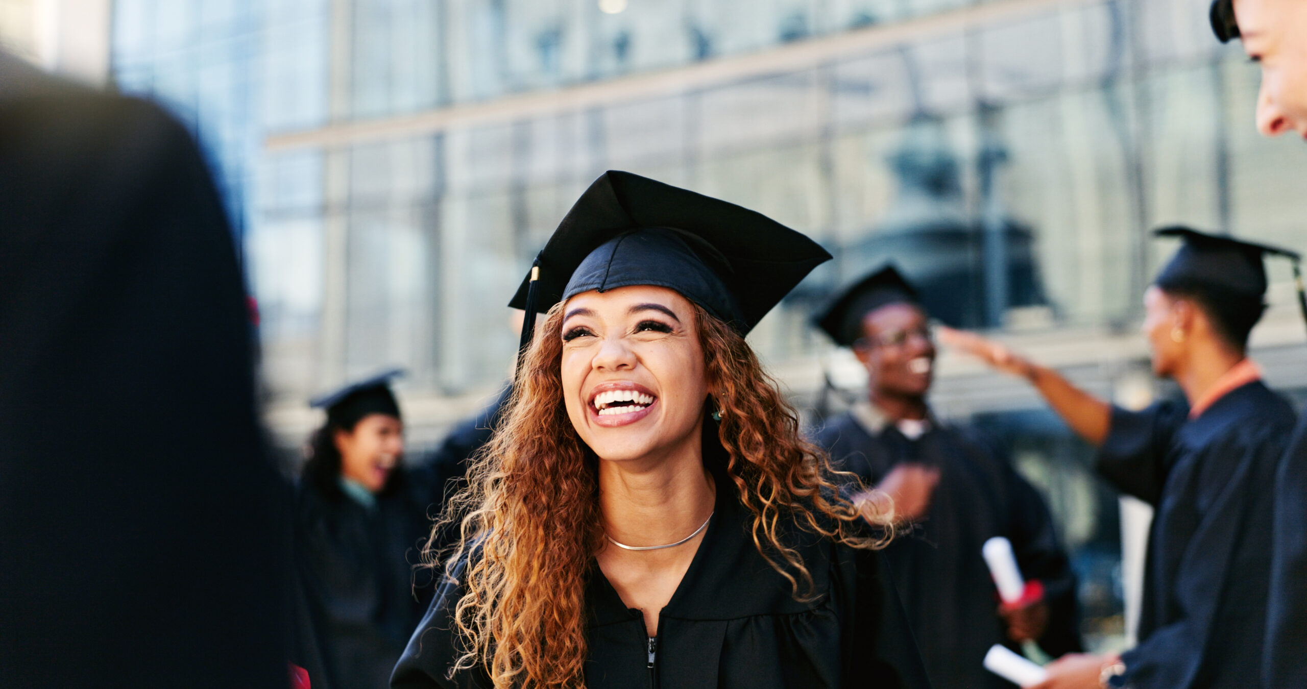 A happy new grad in cap and gown celebrating academic success and future opportunities.